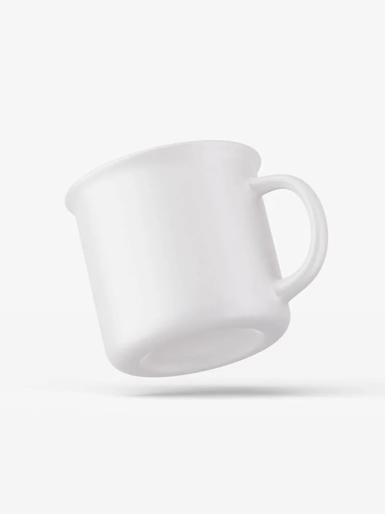Glossy white camp-style ceramic mug tilted diagonally against a pale studio background, with its open rim and right-side handle visible.