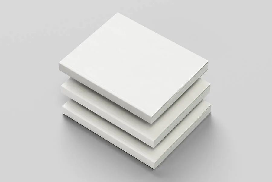 Three plain white hardcover books stacked diagonally on a light gray background, viewed from above at an angle.