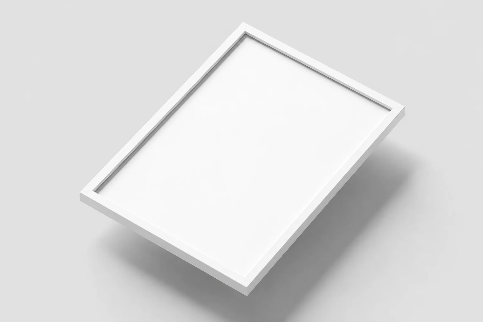White poster frame with a blank insert, lying diagonally on a pale gray surface and viewed from above.