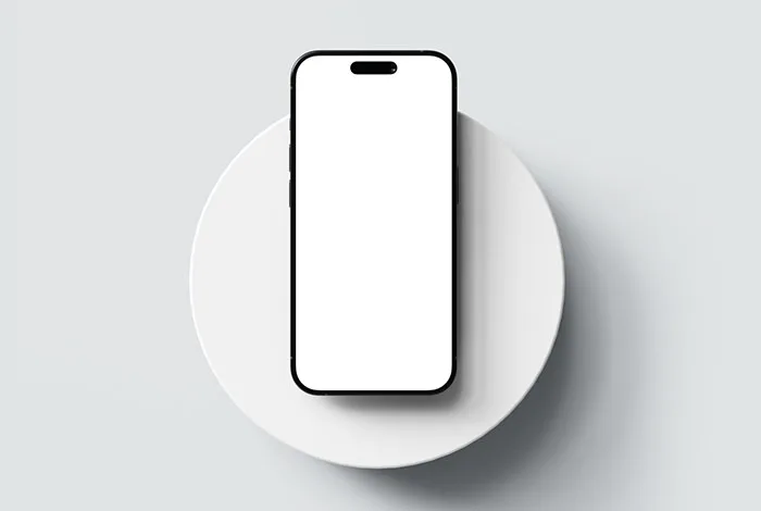 Black-edged smartphone with a blank white screen centered on a round white podium, viewed from above on a pale gray background.